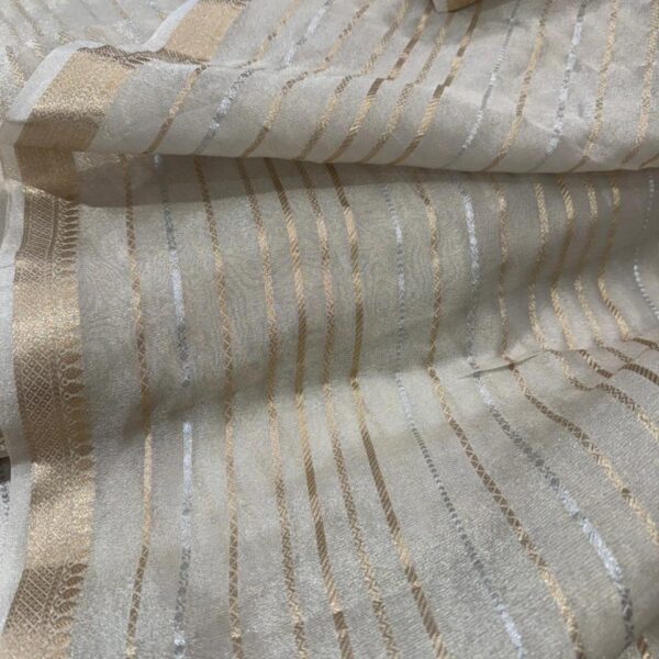 Beautiful Benarasi Tissue Striped Dyeable Fabric!!! A soft & easy to drape fabric , dyeable to the color of your choice , this luxurious fabric boasts of stripes in antique gold & silver and thin borders on either sides! Convert it into a beautiful saree or style it as a Stylish suit utilising the borders for your styling! The color of dusty gold itself is so elegant and boasts of vintage charm !!!
